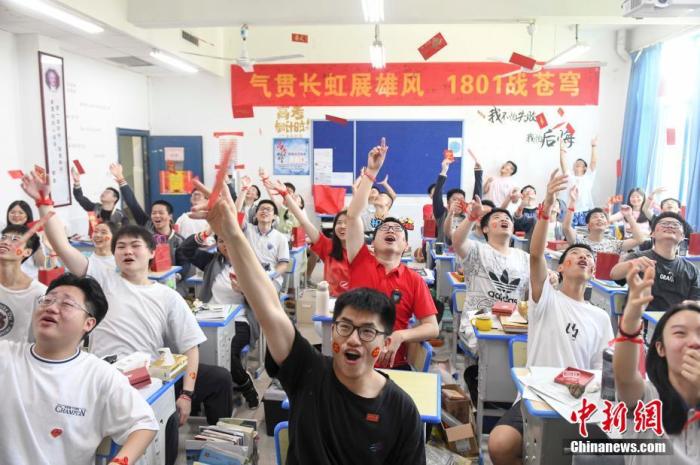 资料图：6月6日，湖南长沙同升湖实验学校教师与考生抛起红包迎接高考。 杨华峰 摄